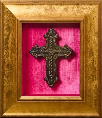 A Rustic Metal Cross Encased in Velvet and Gilded Frame