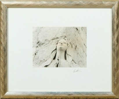 A Framed Photograph of a Weathered Plaster Praying Nun