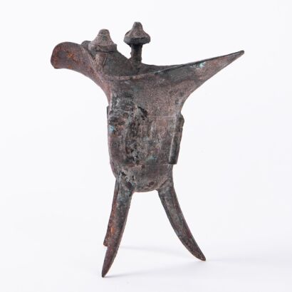 A Chinese Shang Dynasty Style Bronze Ritual Tripod Wine Vessel (Jue) with Taotie Design
