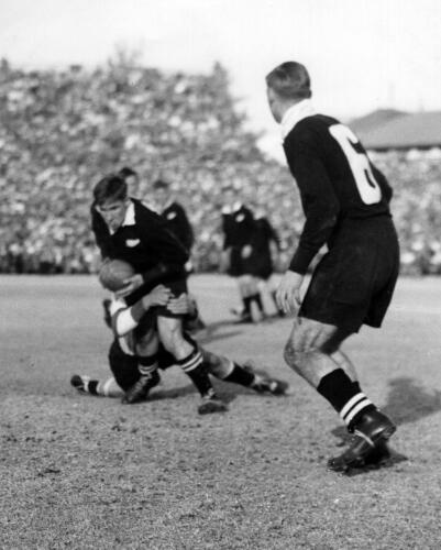 Kotze (Transvaal wing) tackles Black as the New Zealand fly-half K.E.Gudsell (NZ) slips around the blind side with W.A.Meates Number 6 (NZ)