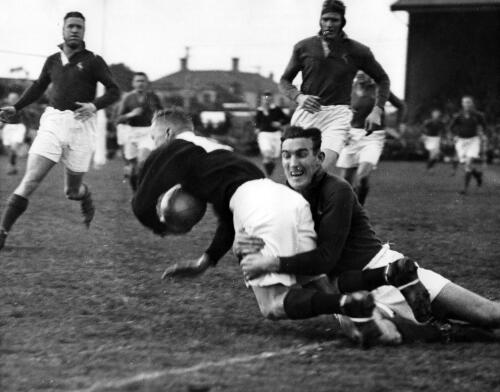 W.F. Bergh (South African back) tackles Kenneth Guy (Wellington) as South African Number 8, G.L. van Reenen (L) and H.J. Martin ( R ) look on