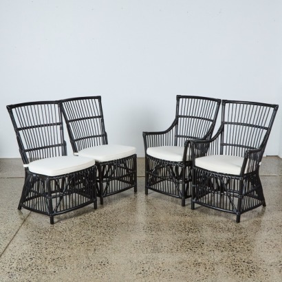 A Set of Four Black Cane Dining Chairs with Two Carvers
