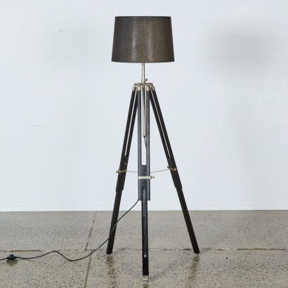 A Tripod Floor Lamp with Shade and Black Metal Accents