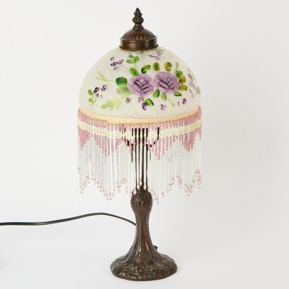 A Metal Tiffany-style table lamp with a heavily beaded glass shade