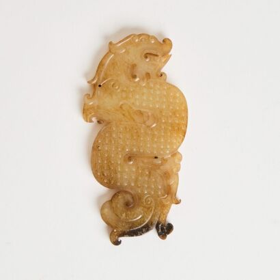 A Chinese Warring States Period Yellow Jade Carving of a Dragon