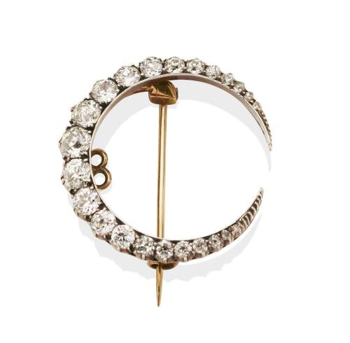 A Victorian diamond crescent brooch, circa 1900, set with a line of graduated old European cut diamonds, estimated total weight 3.28 carats. Yellow gold and silver. Weight 6.66 grams. Width 3cm. 