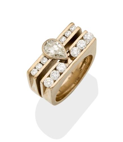 A diamond ring, of architectural design, the central pear-shaped diamond of known weight 0.92 carat, channel set either side with three round brilliant cut diamonds of total known weight 0.24 carats. To be sold with a matching band by Jens Hansen. 18ct wh