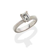 A 0.95 carat solitaire diamond ring, four claw set with an emerald cut diamond of known weight, of estimated colour G and clarity P1. 18ct white gold. Weight 5.80 grams. Size L. Gemmologist's report available.