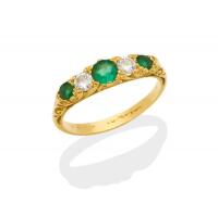 A Victorian style emerald and diamond bridge ring, set with three emeralds and two brilliant cut diamonds. 18ct yellow gold.  Weight 2.7 grams. Size M.