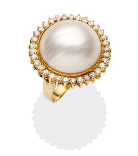 A mabe pearl and diamond ring, the central mabe pearl in a diamond set frame. 14ct yellow gold. Weight 9.87 grams. Size M. Diameter 24mm.