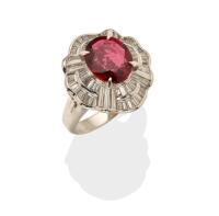 A spinel and diamond ballerina ring, the central oval red spinel of known weight 2.79 carats claw set above a stepped, baguette cut diamond set surround. Known total diamond weight 1.23 carats. 900 platinum and palladium. Weight 10.46 grams. Size L.