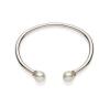 A South Sea pearl and sapphire bangle, the plain polished bangle with pink sapphire rondels and off-round pearl terminals measuring 10.5 - 11mm. 9ct white gold. Weight 37.98 grams. Inside width 7cm.&nbsp;
