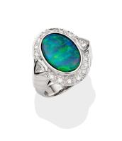 An opal and diamond ring, the oval solid black opal cabochon of known weight 3.3 carats, surrounded by fourteen brilliant diamonds of total weight 0.42 carat and two trilliant cut diamonds of estimated total weight 0.20 carat on a tapered stepped band. 18