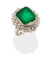 An emerald and diamond cluster ring, four claw set with a rectangular step cut emerald of known weight 9.05 carats with a double row of round brilliant cut and baguette cut diamonds. Total known diamond weight 1.10 carats. 900 Platinum and palladium. Weig