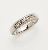 A diamond eternity ring, the front section of the band set with seven round brilliant cut diamonds. 18ct white gold. Weight 3.42 gram. Size L.