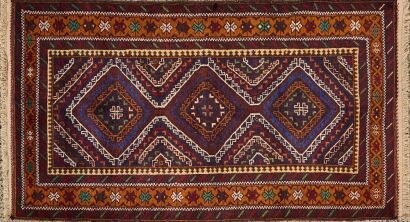 A Handwoven Persian Rug With Geometric Tribal Patterns In Earthy Tones