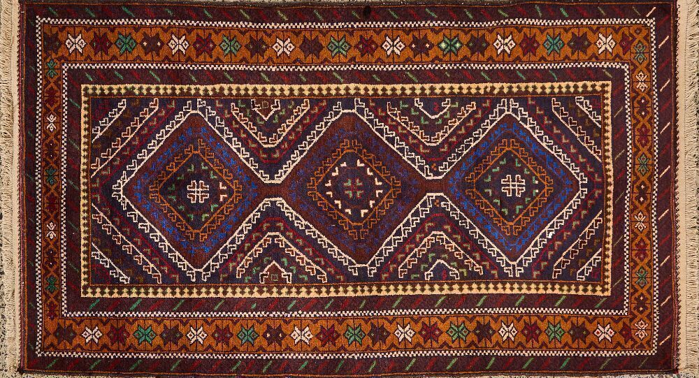 A Handwoven Persian Rug With Geometric Tribal Patterns In Earthy Tones