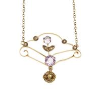 An Edwardian amethyst pendant necklace, the openwork pendant hung on an imitation pearl set oval link chain. 9ct yellow gold. Weight 3.33 grams. Length 40cm. Pendant length 25mm.