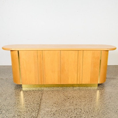 A Curved Blonde Sideboard with Gold-Coloured Metal Detailing
