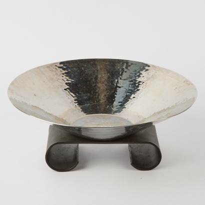 A Hammered Metal Dish On Cast Iron Base