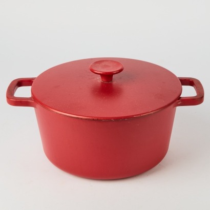 A Red Cast Iron Casserole Dish With Black Lining