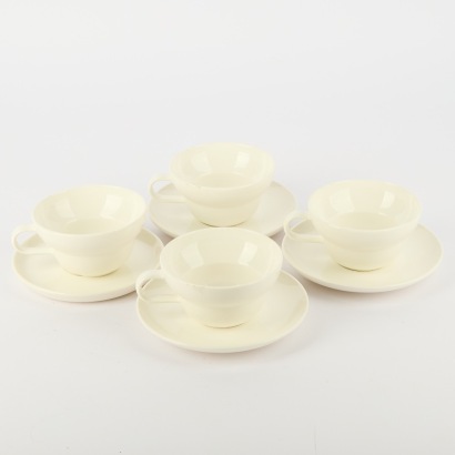 A Set of Four Acme Bibby Cups And Saucers In White Porcelain