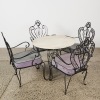 An Ornate Wrought Iron and Marble-Topped Table Outdoor Set