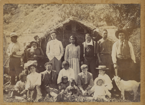 UNKNOWN PHOTOGRAPHER A Group portrait in front of a whare