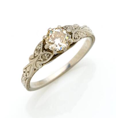 A 0.50 carat solitaire diamond ring, claw set with an old European cut diamond centre of estimated weight, with single cut diamonds on shoulders and a engraved band. Platinum. Weight 3.4 grams. Size K. Gemologist's report available.