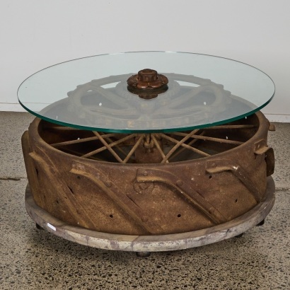 A Tractor Wheel Coffee Table with Glass Top
