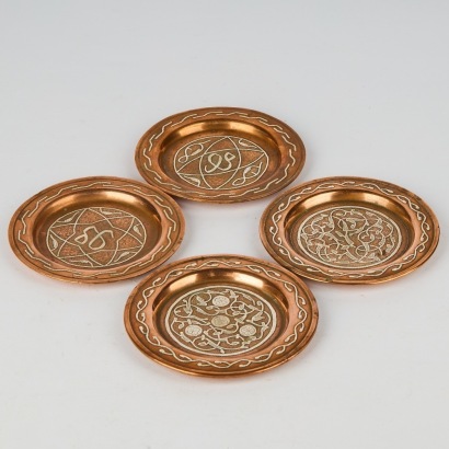 A Set of Four Arabic Copper Overlay Dishes