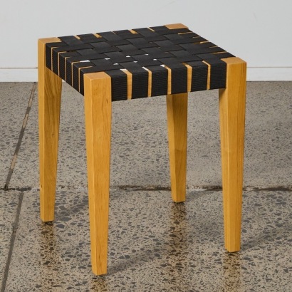 A Wooden Stool With Webbed Seat
