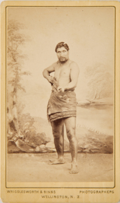 WRIGGLESWORTH AND BINNS A studio portrait of a Māori man with a rifle