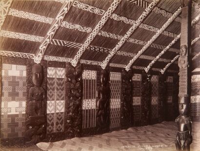 JOSIAH MARTIN Interior view of the Rauru whare whakairo fully decorated with poupou (carved panels), tukutuku (woven panels), kowhaiwhai painted heke and kaho (rafters). Poutokomanawa shown on the left hand side.