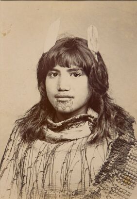 PULMAN'S PHOTOGRAPHIC STUDIO Portrait of Anie Hereni,with a moko kauae, two feathers in her hair and wearing a korowai hukahuka