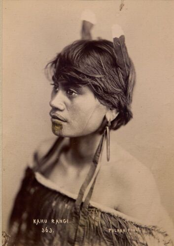 PULMAN'S PHOTOGRAPHIC STUDIO Portrait of Kahu Rangi,with a moko kauae, two feathers in her hair, Pounamu taringa and wearing a korowai hukahuka