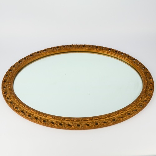 An Oval Ornate Cast Framed Wall Mirror