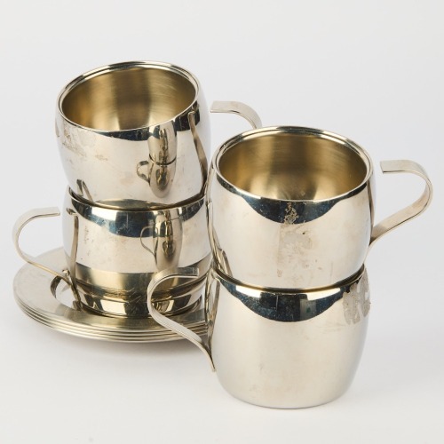 A Set of Four Metal Cups and Saucers