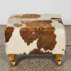 A Cowhide Cube Ottoman On Brass Castors