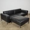 A Black Leather Couch and Ottoman