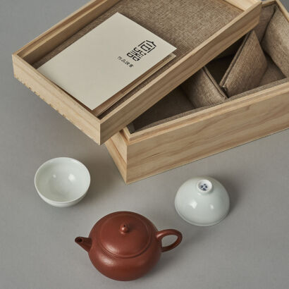 A Chinese Red Clay Teapot (Yong Liming Zhi Mark) and Two White Glazed Tea Cups (He Qi Ruo Shen Mark)