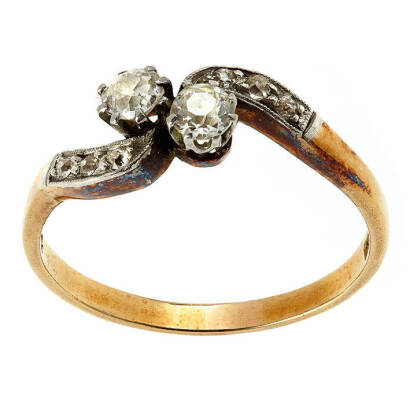 An Edwardian diamond ring, two claw set old European cut diamonds and six single cut diamonds set on shoulders, crossover design. 18ct yellow gold. Weight 3.0 grams. Size P.