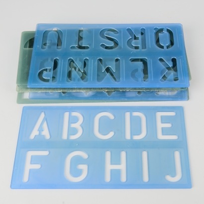 A collection of fifteen vintage plastic stencils letters and numbers