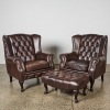 A Pair of Leather Chesterfield Wingback Armchairs and Ottoman