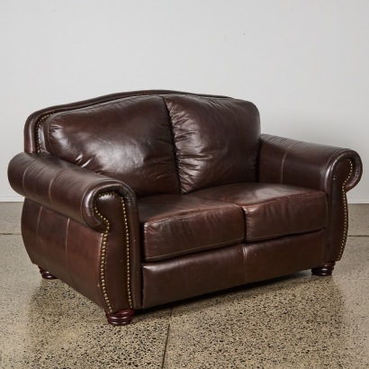 A Pair of Leather Chesterfield Wingback Armchairs and Ottoman