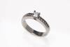A diamond ring, claw set round brilliant cut diamond centre of estimated weight 0.34 carat, six channel set round brilliant cut diamonds down each shoulder of estimated total weight 0.20 carats. Platinum. Weight 5.5 grams. Size J.