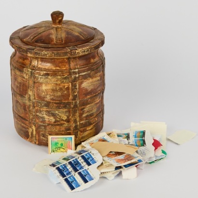 A Vintage Tobacco Jar Filled with Spent Stamps from accross the World