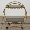 A Bar Cart with Black Glass Shelves in Gold Finish
