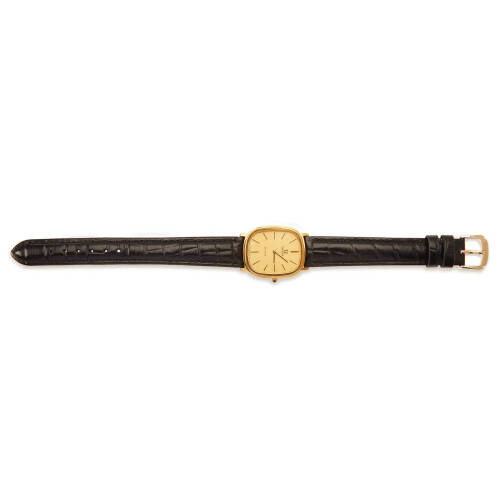 A Gentleman's gold plated and stainless steel De Ville wristwatch, Omega. Manual. 32x27mm. Cushion shaped case. Gold dial with applied black batons. Non-original black leather strap.