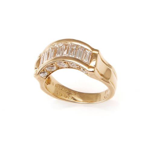 A diamond dress ring, Piaget, circa 1990. Serial number A02997. A curved row of eight channel set calibre-cut baguette cut diamonds of estimated total weight 1.30 carats, with 10 bead set round brilliant cut diamonds of estimated total weight 0.90 carats 